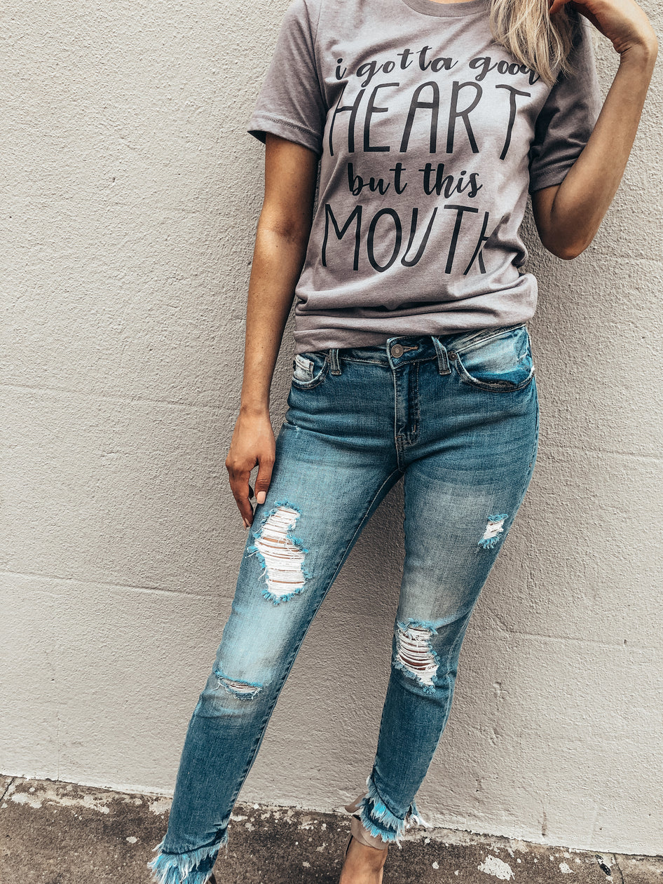 Gray t-shirt with a sassy saying paired with ripped, frayed-hem jeans.
