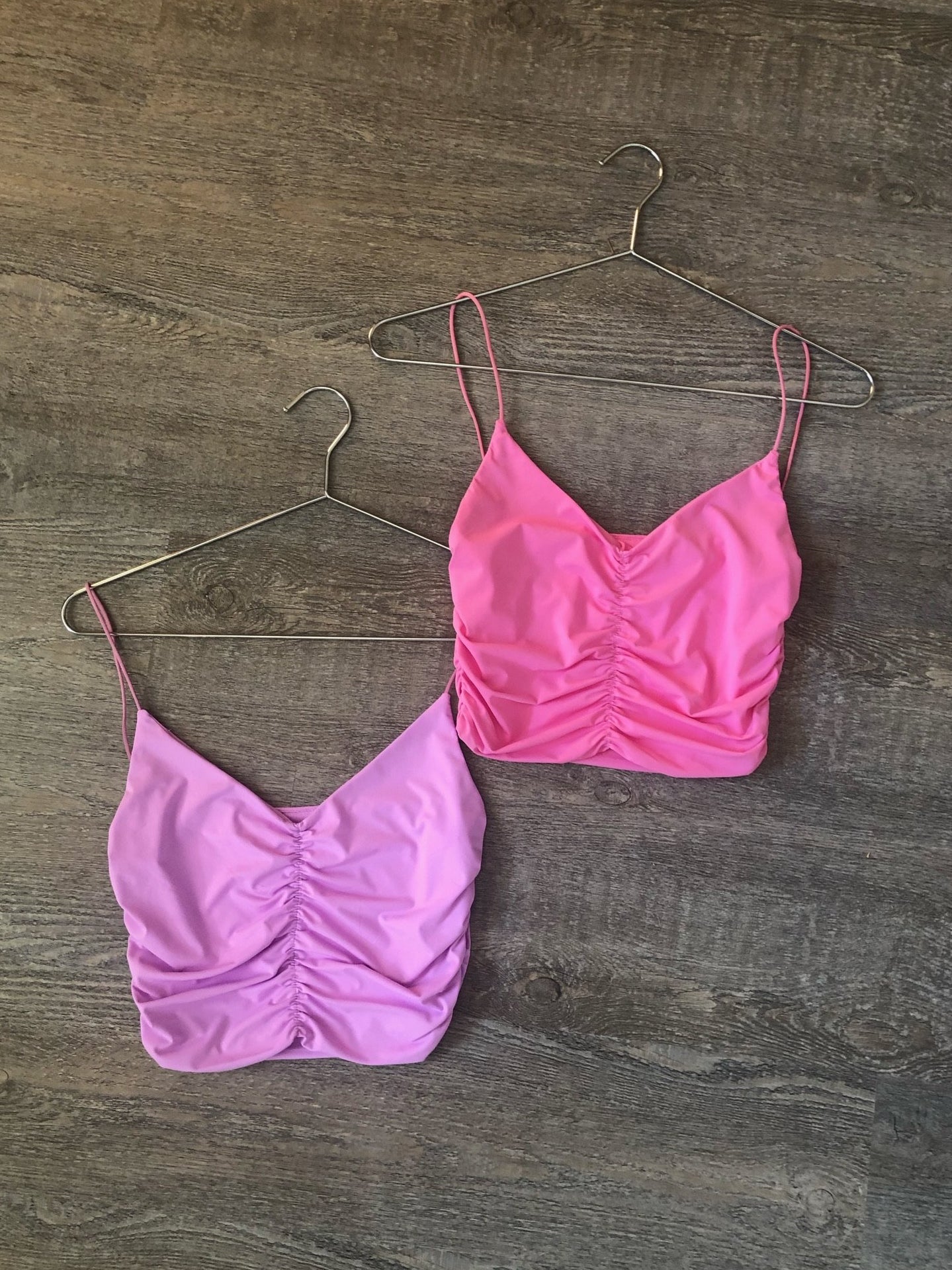 Bubblegum Top: Pink and lilac ruched crop tops on hangers.
