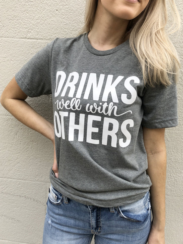 Gray Drinks Well With Others tee shirt with white lettering

