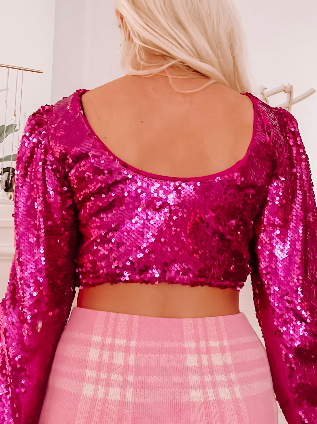 Fuchsia sequin crop top with long sleeves, shown from the back.
