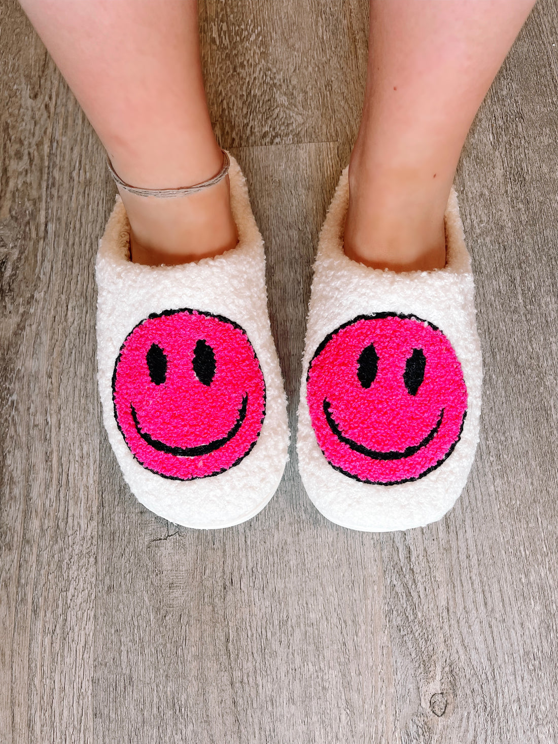 Superpink Smiley slippers: cozy white fuzzy slippers with hot pink smiley faces.
