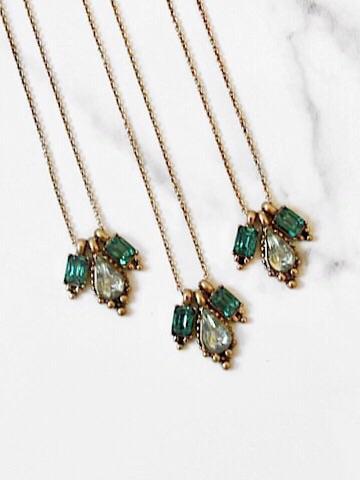 Elegant Dew Drop necklace featuring shimmering emerald and clear cubic zirconia accents on a delicate gold chain.
