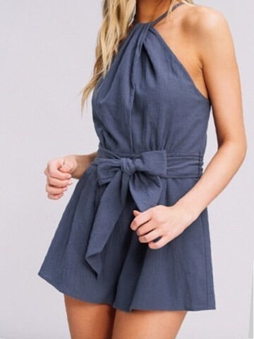 Blue linen halter romper with a self-tie waist, styled on a model.
