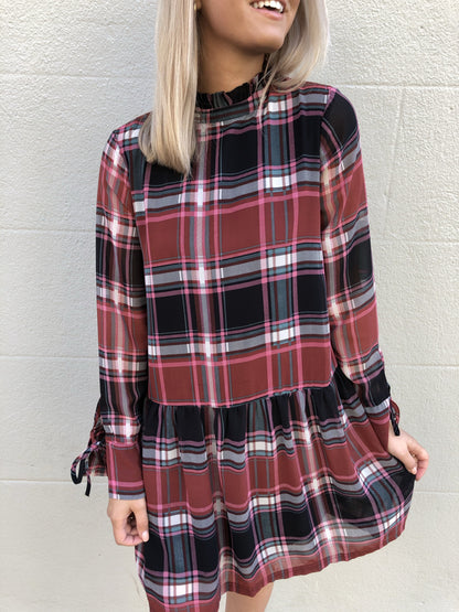 Red, black, and pink plaid long-sleeve mini dress with tie cuffs.
