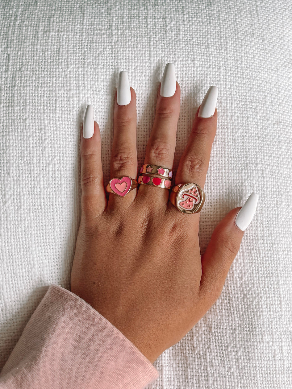 Lots of Love Ring: Gold rings featuring pink heart & mushroom designs.
