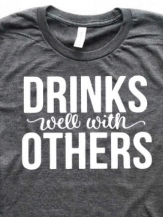 Dark gray tee shirt featuring a white "Drinks well with others" graphic.
