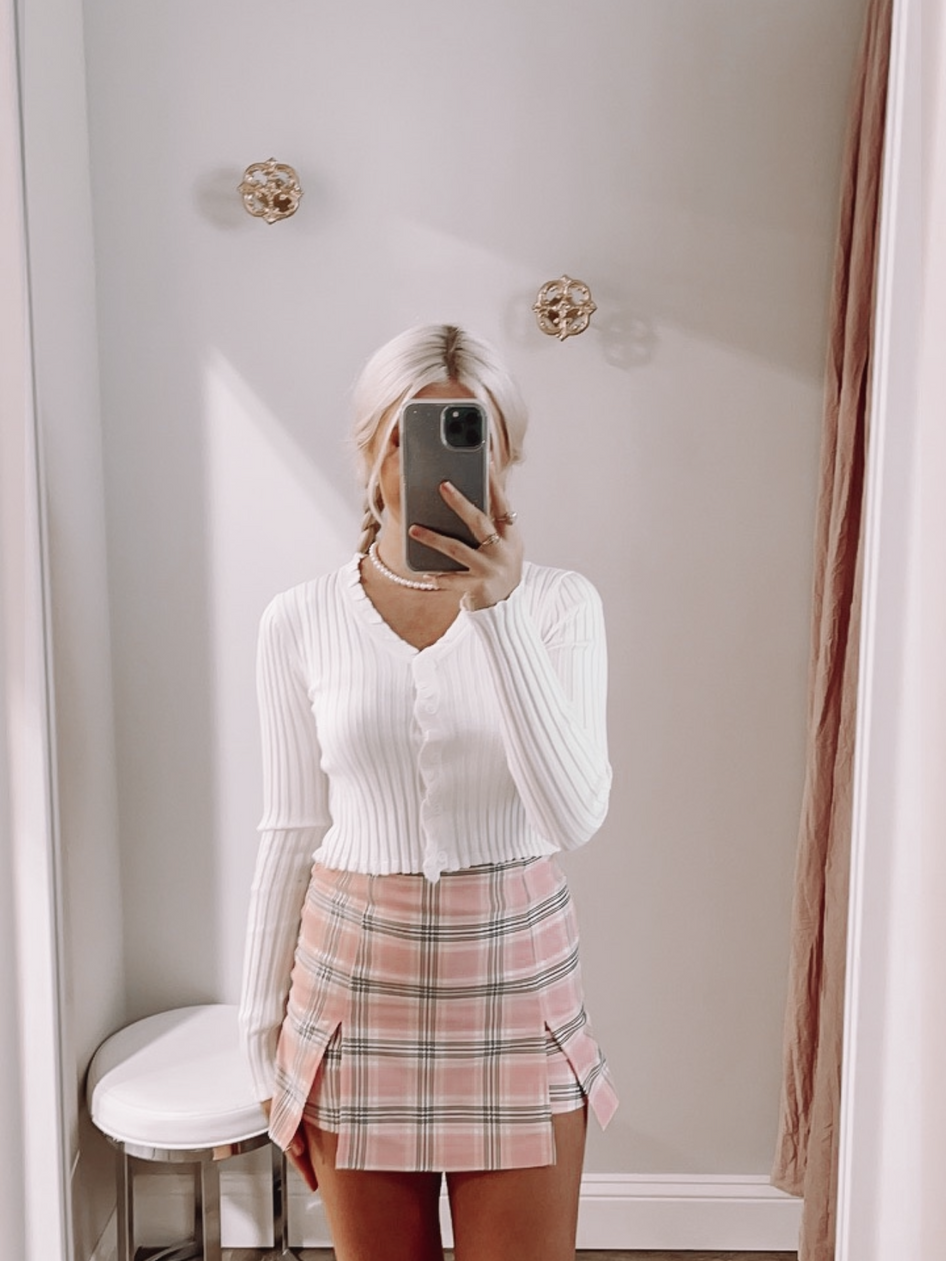 White ribbed knit button cardigan with pink plaid mini skirt
