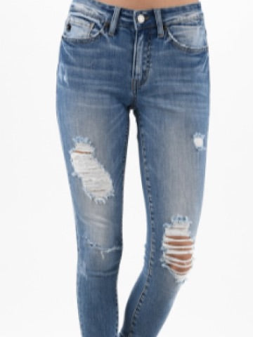 Light wash distressed skinny jeans with several knee rips.
