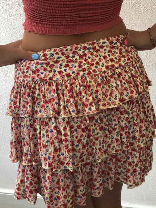 Tiered floral mini skirt in cream, pink, and red.
