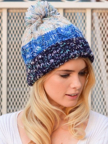 Blue Pom Pom Beanie: Chunky knit winter hat with multicolor stripes and fluffy pom.
