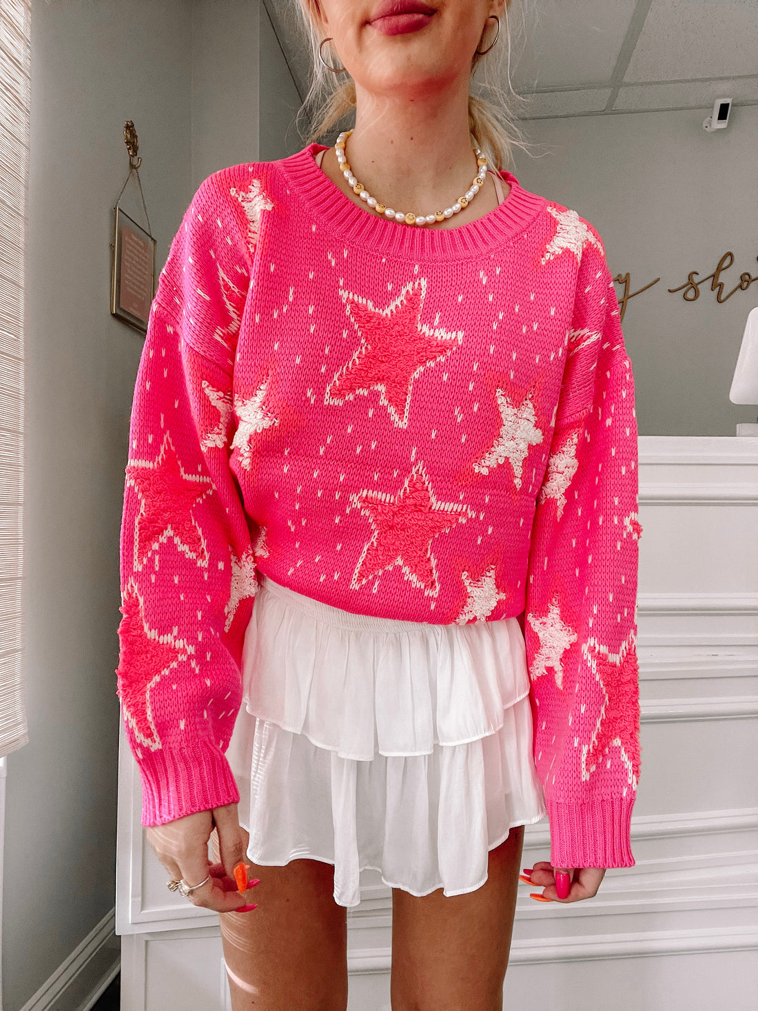 Pink Popstar Punch sweater with white star details; cozy knit fabric.
